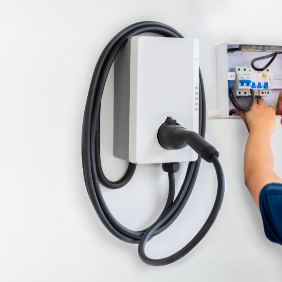 Technician working on a level 2 electric charger in a garage.